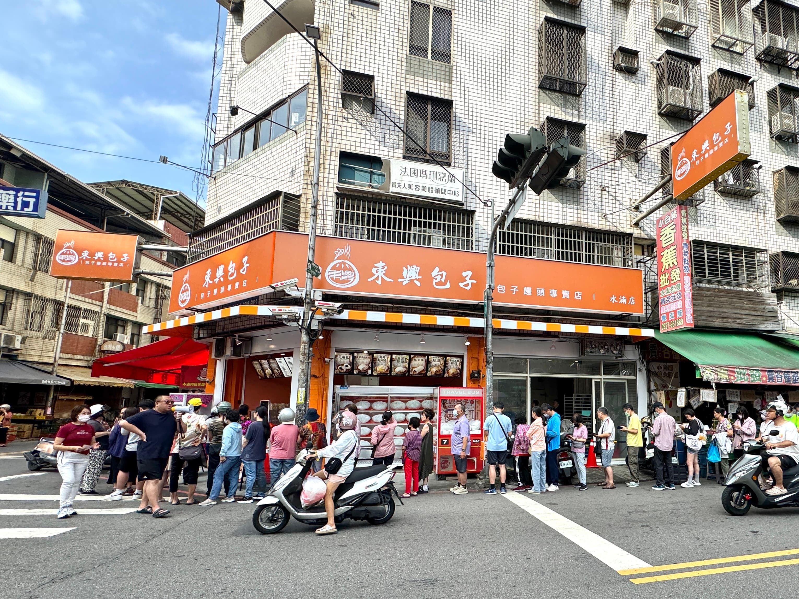 東興包子水湳店新址橘色招牌與排隊人潮